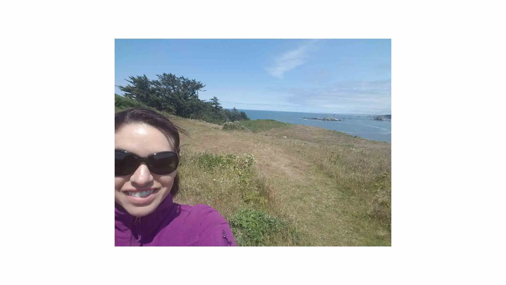 Woman on a cliffside wearing sunglasses