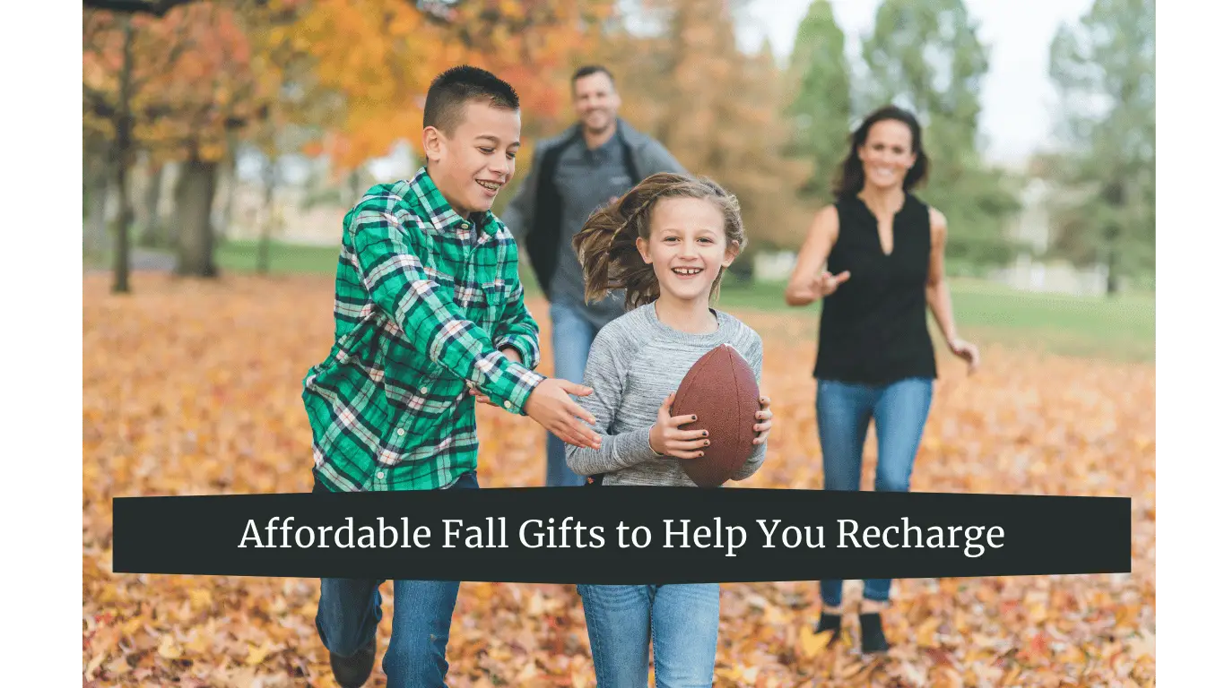 A family playing football in a park during fall, with autumn leaves covering the ground.